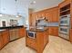 View of the kitchen island with microwave, sink, and surrounding cabinets and appliances at 3050 Wentworth Way, Tarpon Springs, FL 34688