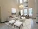 Living room with large windows, high ceiling, and stylish furniture at 3050 Wentworth Way, Tarpon Springs, FL 34688