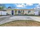 Cute yellow house with a blue door, landscaping, and a long driveway at 6366 38Th N Ave, St Petersburg, FL 33710