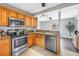 Well-equipped kitchen featuring stainless steel appliances, wood cabinets, and granite countertops, flowing into the living area at 6366 38Th N Ave, St Petersburg, FL 33710