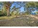 Large backyard with firepit, mature trees, and screened patio at 7108 Riverwood Blvd, Tampa, FL 33615