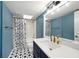 Updated bathroom with navy vanity, gold fixtures, and patterned tile floor at 7108 Riverwood Blvd, Tampa, FL 33615