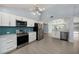 Open concept kitchen boasts stainless steel appliances and white cabinetry at 7108 Riverwood Blvd, Tampa, FL 33615