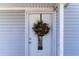 White front door adorned with a rustic autumnal wreath at 8346 Fantasia Park Way, Riverview, FL 33578