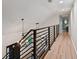 Upstairs hallway with hardwood floors and modern lighting fixtures at 8718 Hickorywood Ln, Tampa, FL 33615