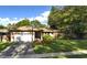 Charming single-story house with a two car garage and manicured lawn at 915 Rolling Hills Dr, Palm Harbor, FL 34683