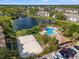 Aerial view of community pool, volleyball court, and lake at 10263 Gandy N Blvd # 202, St Petersburg, FL 33702