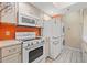 White kitchen appliances and orange backsplash at 10263 Gandy N Blvd # 202, St Petersburg, FL 33702