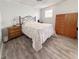 Bedroom with light gray walls, wood-look floors, and window providing natural light at 110 W Saint Annes Cir, Apollo Beach, FL 33572