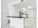 Open concept kitchen featuring stainless steel appliances, white cabinets, and black countertops on white tile floor at 1847 Shore S Dr # 509, South Pasadena, FL 33707
