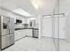 Well-lit kitchen featuring stainless steel appliances, white cabinets, and ample counter space on white tile floor at 1847 Shore S Dr # 509, South Pasadena, FL 33707
