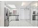 Well-lit kitchen featuring stainless steel appliances, white cabinets, and ample counter space on white tile floor at 1847 Shore S Dr # 509, South Pasadena, FL 33707