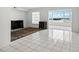 Spacious living room with white tile flooring, minimalist decor, and a large window offering scenic views at 1847 Shore S Dr # 509, South Pasadena, FL 33707
