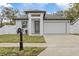 Modern one-story house with a white exterior, two-car garage, and landscaped front yard at 200 W Kirby St, Tampa, FL 33604