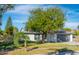 Charming single-story house with a lush green lawn and large tree at 2372 Millwood Ln, Clearwater, FL 33763