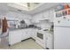 Bright eat-in kitchen, featuring white cabinetry, granite countertops, and modern appliances at 254 Cypress Ln # 254, Oldsmar, FL 34677