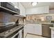 Bright kitchen with white cabinets, granite countertops, and stainless steel appliances at 36750 Us Highway 19 N # 19219, Palm Harbor, FL 34684