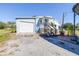 Mobile home exterior features a carport, covered porch, and a fenced yard at 4043 Fox Ridge Blvd, Wesley Chapel, FL 33543