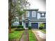 Two-story townhome with blue exterior, two-car garage, and landscaped front yard at 4445 Amberly Oaks Ct, Tampa, FL 33614