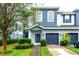 Two-story townhome with blue exterior, two-car garage, and landscaped front yard at 4445 Amberly Oaks Ct, Tampa, FL 33614
