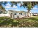 Side view of the newly renovated home showcasing its fresh paint and landscaping at 6000 Francis Drive, Apollo Beach, FL 33572