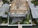 Aerial view of home under construction, showing roof framework with concrete base and waterfront access at 6457 1St Palm Pt, St Pete Beach, FL 33706