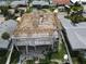 New home construction aerial showcases the modern building's framing near neighboring homes and sunny skies at 6457 1St Palm Pt, St Pete Beach, FL 33706
