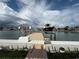 Boat dock image featuring a boat on a lift against a backdrop of luxurious waterfront homes and a cloudy sky at 6457 1St Palm Pt, St Pete Beach, FL 33706