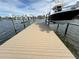 Tan composite boat dock with a black center console boat on a lift at 6457 1St Palm Pt, St Pete Beach, FL 33706