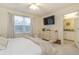 Bright bedroom with a large bed, dresser, and ensuite bathroom access at 7013 Summer Holly Pl, Riverview, FL 33578
