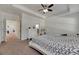 Main bedroom with king-size bed, carpeted floor, and access to the bathroom at 10439 Waterstone Dr, Riverview, FL 33578