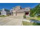 Two-story house with a large beige exterior, stone accents, and a three-car garage at 10439 Waterstone Dr, Riverview, FL 33578