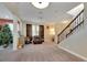Open living area with carpeted floors, staircase, and a Christmas tree at 10439 Waterstone Dr, Riverview, FL 33578