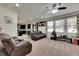 Bright living room with leather furniture, ceiling fan, and view into kitchen area at 10439 Waterstone Dr, Riverview, FL 33578