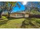 Large backyard with grassy area and mature trees at 1116 N Riverhills Dr, Temple Terrace, FL 33617