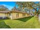 Home's backyard features a grassy lawn and trees at 1116 N Riverhills Dr, Temple Terrace, FL 33617