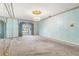 Spacious bedroom with mirrored walls, chandelier, and light blue patterned wallpaper at 1116 N Riverhills Dr, Temple Terrace, FL 33617