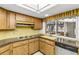 Retro kitchen features wood cabinets, granite countertops, and stainless steel appliances at 1116 N Riverhills Dr, Temple Terrace, FL 33617