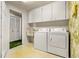 Laundry room with washer, dryer, cabinets, and utility sink at 1116 N Riverhills Dr, Temple Terrace, FL 33617