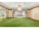 Living room with green shag carpet, mirrored walls, and a crystal chandelier at 1116 N Riverhills Dr, Temple Terrace, FL 33617