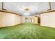 View of a large living area with green wall-to-wall carpeting and decorative wallpaper at 1116 N Riverhills Dr, Temple Terrace, FL 33617