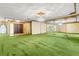 Large living room with green shag carpet, mirrored walls, and a crystal chandelier at 1116 N Riverhills Dr, Temple Terrace, FL 33617