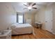 Bright bedroom featuring a comfortable bed, wood floors, and a built-in desk at 12303 Foxmoor Peak Dr, Riverview, FL 33579
