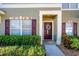 Townhome's front entrance with maroon door and holiday wreath at 12303 Foxmoor Peak Dr, Riverview, FL 33579