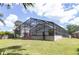 Spacious backyard featuring a screened-in pool, outdoor furniture, and manicured lawn at 14324 Moon Flower Dr, Tampa, FL 33626