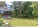Expansive backyard featuring mature trees, lush grass, and a screened-in pool area for outdoor enjoyment at 14324 Moon Flower Dr, Tampa, FL 33626