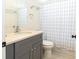 Bathroom features a gray vanity with solid surface counters, and a blue and white patterned shower curtain at 14324 Moon Flower Dr, Tampa, FL 33626