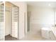 Open bathroom with a glass-enclosed shower, soaker tub, and a spacious walk-in closet at 14324 Moon Flower Dr, Tampa, FL 33626