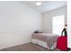 A simple bedroom with a neutral-toned bed, blind-covered window, and a ceiling fan at 14324 Moon Flower Dr, Tampa, FL 33626