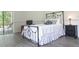 Comfortable bedroom features a wrought iron bed frame and an adjacent sliding glass door to the outside at 14324 Moon Flower Dr, Tampa, FL 33626